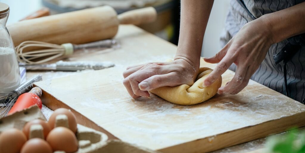 Massa de pão crua sendo preparada sobre bancada de cozinha