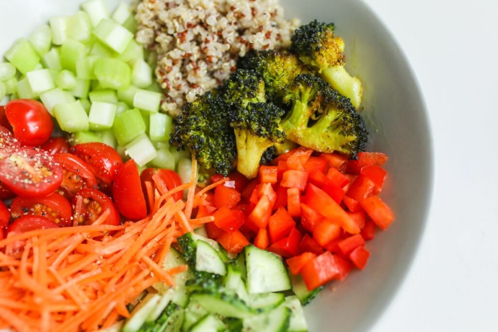 tigela com tomate-cereja, cenoura ralada, pepino, pimentão e brócolis picados