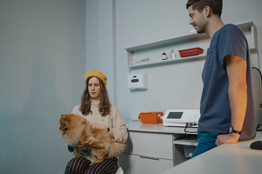 Tutora em consulta veterinária com seu cachorro no colo